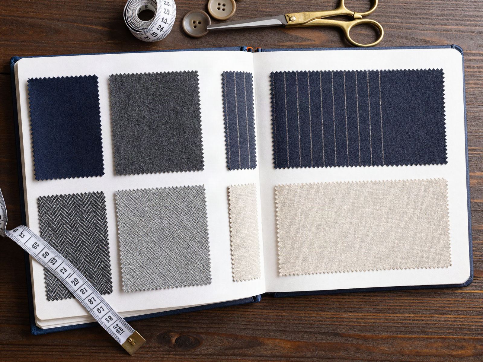An open fabric swatch book with scissors and a tape measure