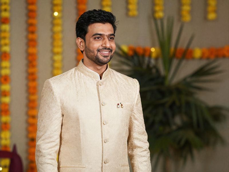 A groom in an ivory bandhgala at an evening wedding